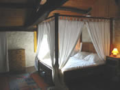 Trs grand lit  baldaquin, en chne, dans la chambre principale